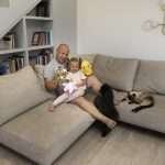 A father sits with his daughter in a newly finished family room located in a basement.