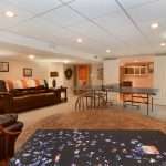 A multi-use basement with furniture, a kitchenette, and a dining area
