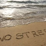The words “No Stress” are written in the sand